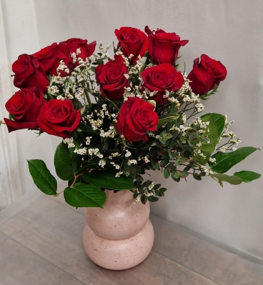 Dozen red roses in pink vase